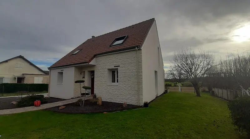 Maison à Caen après isolation extérieure avec parement effet pierre et enduit blanc »