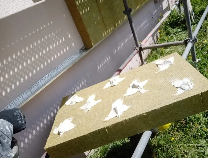 Panneau isolant fibreux posé sur une façade avec échafaudage lors d'un chantier d'ITE dans le Calvados